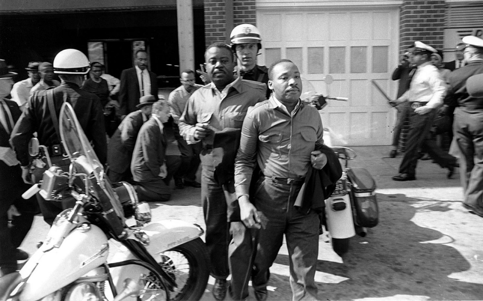 El pastor Ralph Abernathy, left, y el pastor Martin Luther King Jr., son arrestados por la policías después de conducir a  manifestantes en la sección comercial de Birmingham, Ala.,el 12 de abril de  1963.